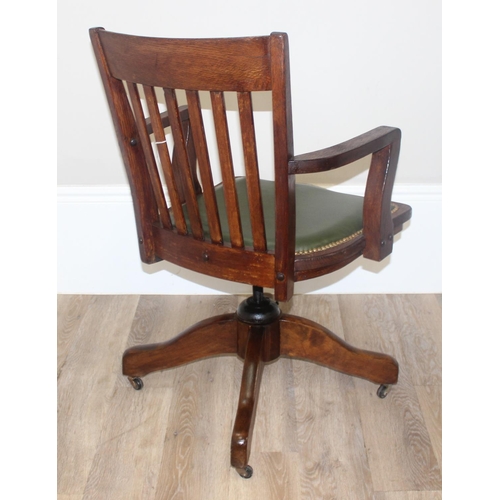 45 - A vintage slat back office chair with green leather seat, approx 92cm tall