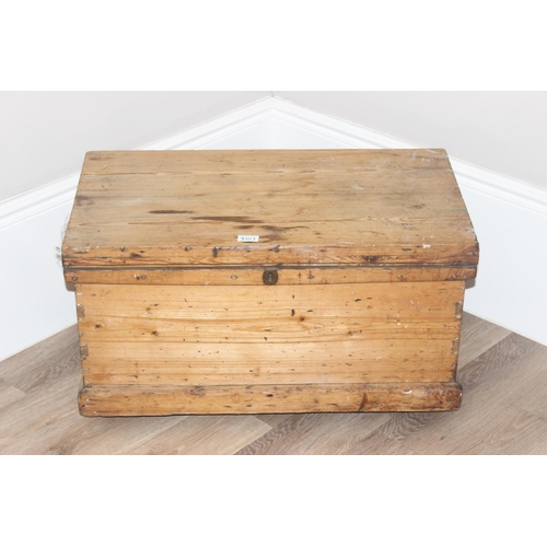 49 - Vintage pine wooden trunk on wheels with wrought iron handles and hinged lid, approx 77cm W x 44cm D... 