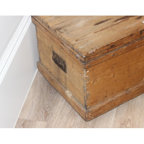 49 - Vintage pine wooden trunk on wheels with wrought iron handles and hinged lid, approx 77cm W x 44cm D... 