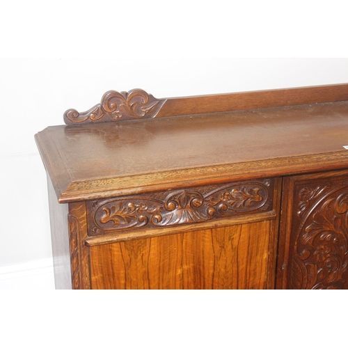 15 - A large 17th century style heavily carved oak sideboard with a central carved cupboard flanked by 2 ... 