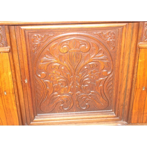 15 - A large 17th century style heavily carved oak sideboard with a central carved cupboard flanked by 2 ... 