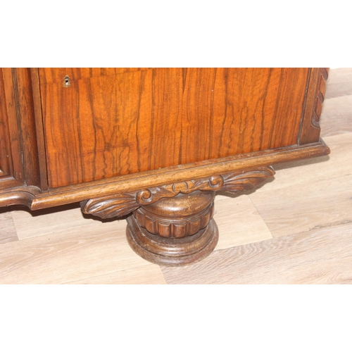 15 - A large 17th century style heavily carved oak sideboard with a central carved cupboard flanked by 2 ... 