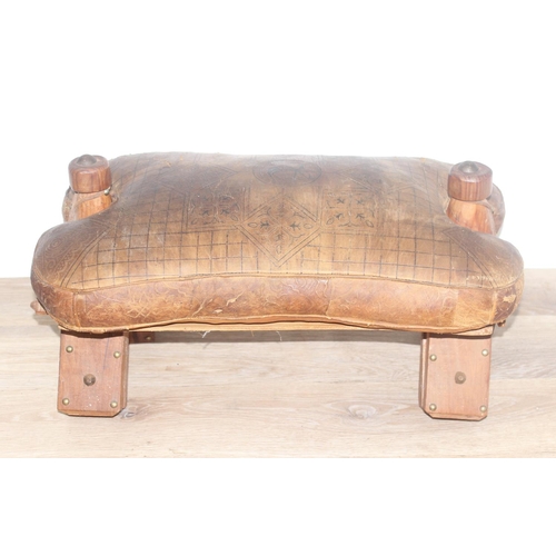 19 - A vintage leather topped camel stool, a further small pine stool with embossed leather top decorated... 