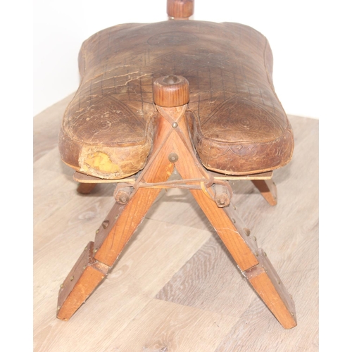 19 - A vintage leather topped camel stool, a further small pine stool with embossed leather top decorated... 