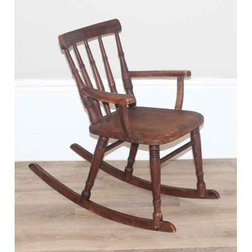 14 - An antique Swedish child's stick back rocking chair, bearing antique shipping label to base, likely ... 