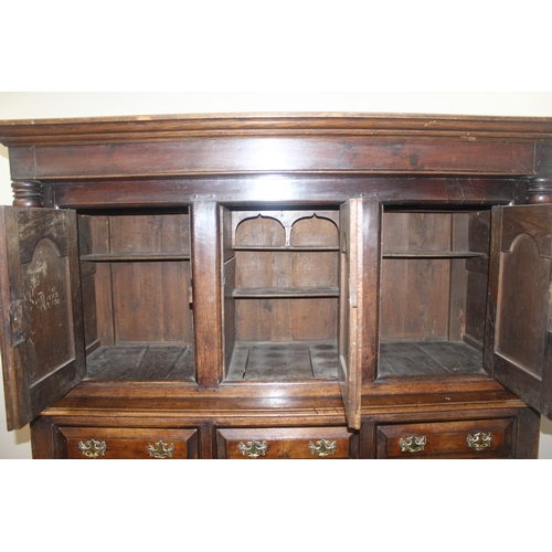 16 - An 18th century oak court cupboard with Georgian brass handles, dated 1754 and believed to be of tha... 