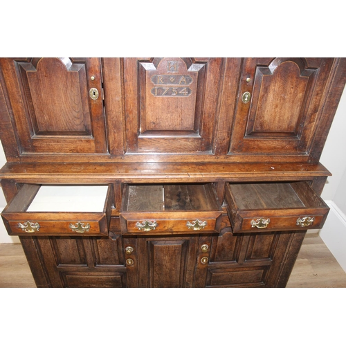 16 - An 18th century oak court cupboard with Georgian brass handles, dated 1754 and believed to be of tha... 