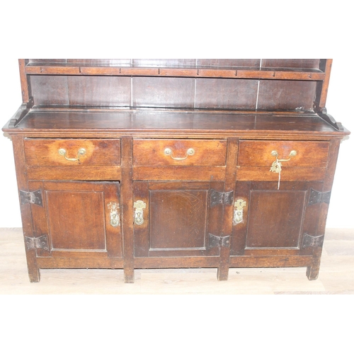 23 - An antique country oak dresser, likely 18th century, the base comprising of 3 cupboards under 3 draw... 