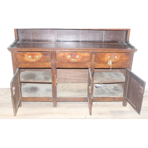 23 - An antique country oak dresser, likely 18th century, the base comprising of 3 cupboards under 3 draw... 