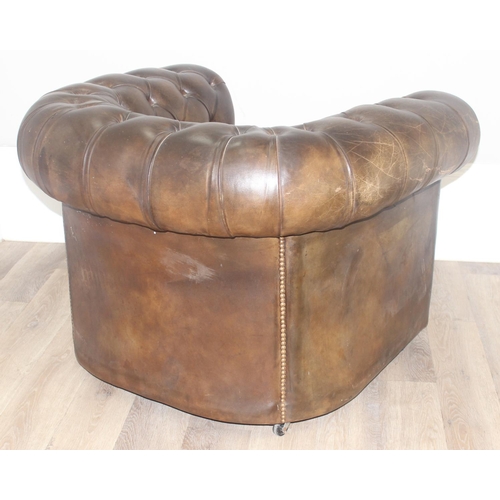 12 - A Chesterfield style leather club chair to match the sofa in the previous lot, distressed brown/ gre... 