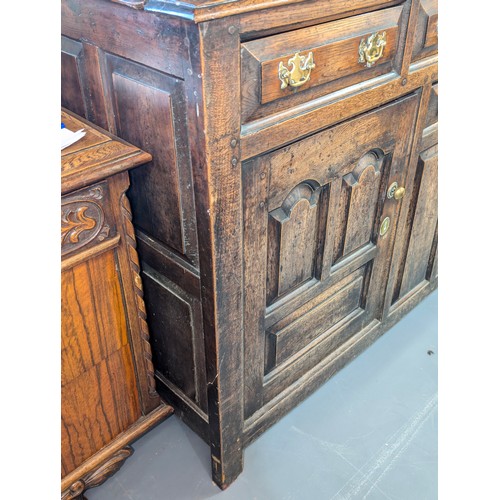 16 - An 18th century oak court cupboard with Georgian brass handles, dated 1754 and believed to be of tha... 