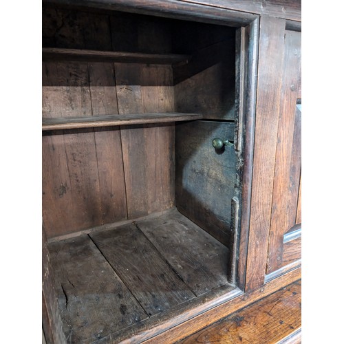 16 - An 18th century oak court cupboard with Georgian brass handles, dated 1754 and believed to be of tha... 