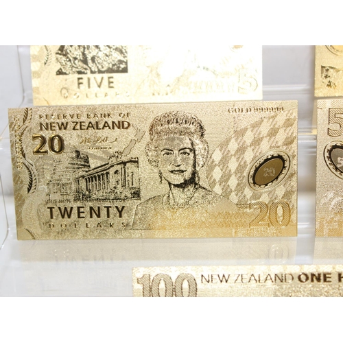 1215 - A set of New Zealand Polymer gold coloured banknotes, in display folder, denominations from $5 to $1... 