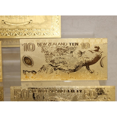 1215 - A set of New Zealand Polymer gold coloured banknotes, in display folder, denominations from $5 to $1... 