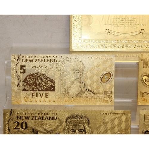 1215 - A set of New Zealand Polymer gold coloured banknotes, in display folder, denominations from $5 to $1... 