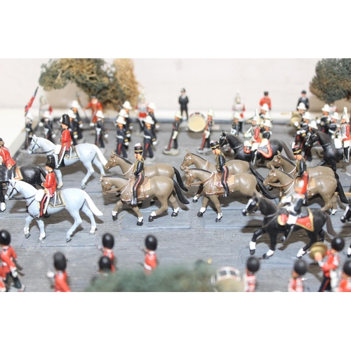 1414 - A trooping of the colour model soldier diorama in perspex glazed case, approx 43cm wide