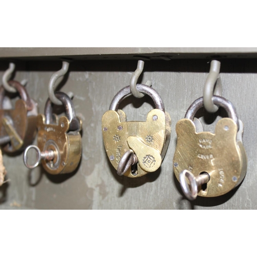 1536 - A cased display of 27 Victorian and early 20th century brass padlocks with keys, various makers and ... 