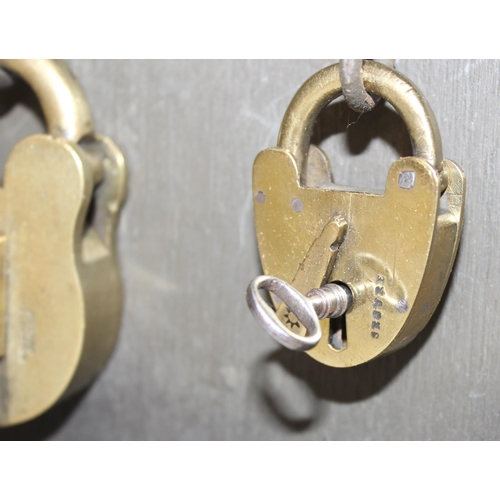 1536 - A cased display of 27 Victorian and early 20th century brass padlocks with keys, various makers and ... 