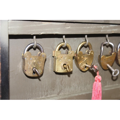 1536 - A cased display of 27 Victorian and early 20th century brass padlocks with keys, various makers and ... 