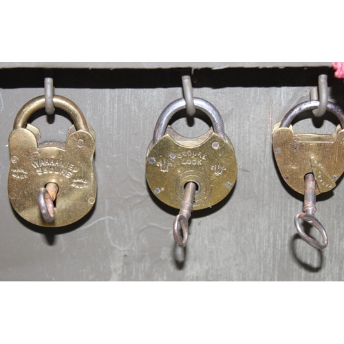 1536 - A cased display of 27 Victorian and early 20th century brass padlocks with keys, various makers and ... 