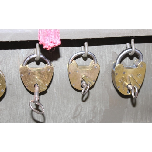 1536 - A cased display of 27 Victorian and early 20th century brass padlocks with keys, various makers and ... 