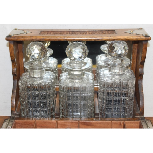 1537 - A 19th century oak 3 bottle tantalus with secret compartment, the body with carved details, approx 3... 