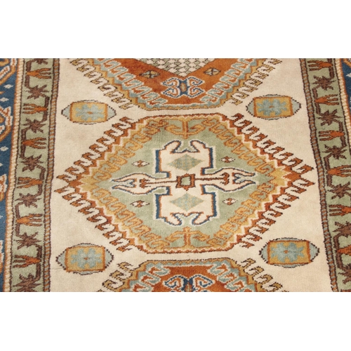 205 - A vintage hand knotted beige ground rug, likely Caucasian in origin, approx 134cm x 95cm