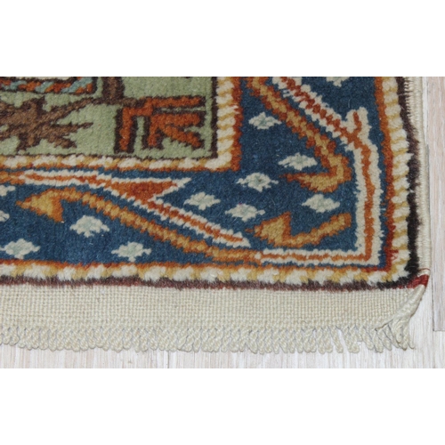 205 - A vintage hand knotted beige ground rug, likely Caucasian in origin, approx 134cm x 95cm