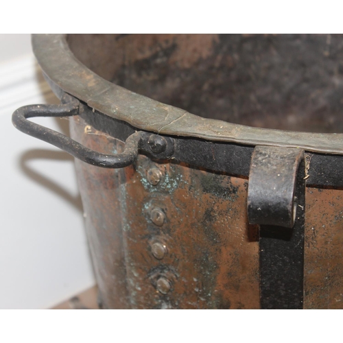 149 - A Victorian copper boiler with riveted join presented in a vintage blacksmith made wrought iron stan... 