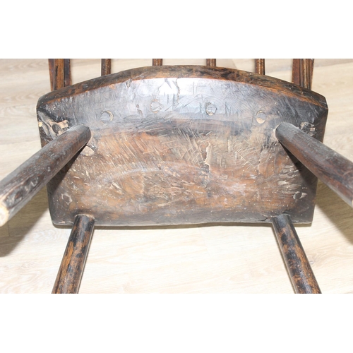 135 - A primitive antique Elm seated chair of comb-back form, possibly Welsh, 19th century or earlier, app... 