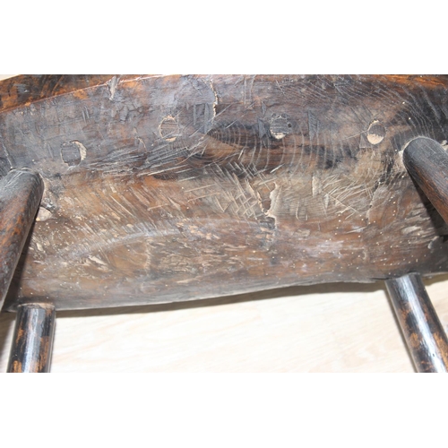 135 - A primitive antique Elm seated chair of comb-back form, possibly Welsh, 19th century or earlier, app... 