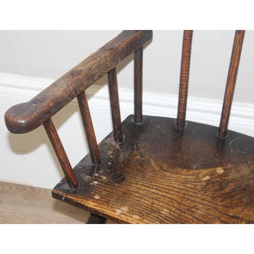 135 - A primitive antique Elm seated chair of comb-back form, possibly Welsh, 19th century or earlier, app... 