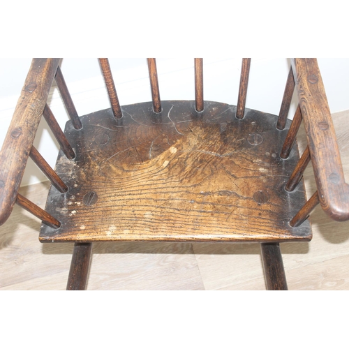 135 - A primitive antique Elm seated chair of comb-back form, possibly Welsh, 19th century or earlier, app... 