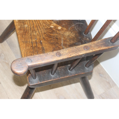 135 - A primitive antique Elm seated chair of comb-back form, possibly Welsh, 19th century or earlier, app... 