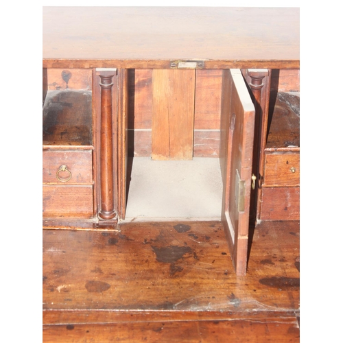 129 - A Georgian mahogany bureau with fitted interior, 4 long drawers with brass drop handles and bracket ... 