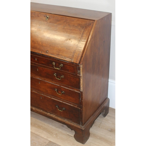 129 - A Georgian mahogany bureau with fitted interior, 4 long drawers with brass drop handles and bracket ... 