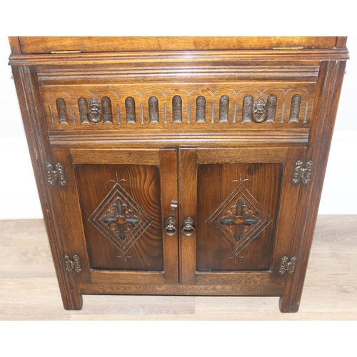 171 - A 17th century style oak cocktail cabinet with mirrored glass interior, likely by Ercol or Old Charm... 