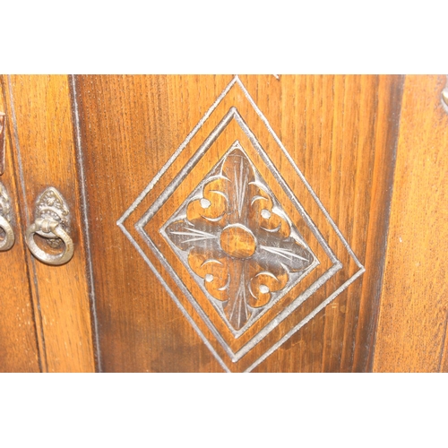 171 - A 17th century style oak cocktail cabinet with mirrored glass interior, likely by Ercol or Old Charm... 