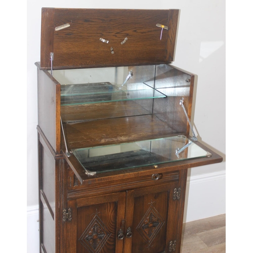 171 - A 17th century style oak cocktail cabinet with mirrored glass interior, likely by Ercol or Old Charm... 