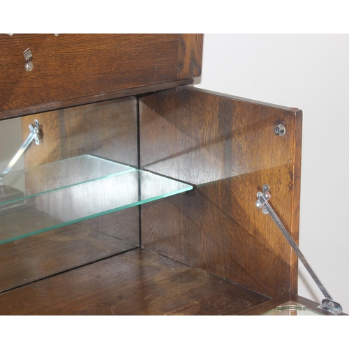 171 - A 17th century style oak cocktail cabinet with mirrored glass interior, likely by Ercol or Old Charm... 