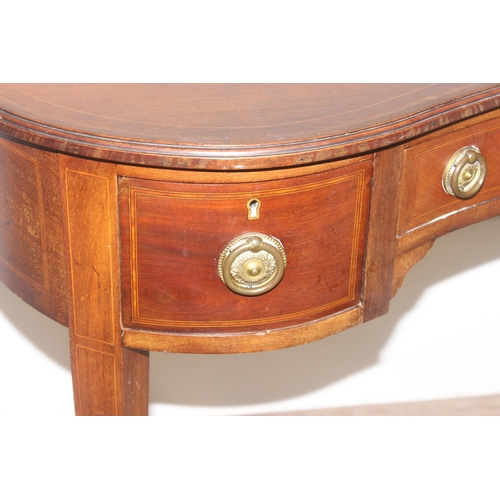 75 - An Edwardian Sheraton Revival period kidney shaped mahogany writing desk with 3 drawers, brass ring ... 