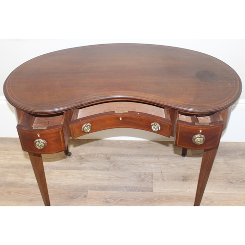 75 - An Edwardian Sheraton Revival period kidney shaped mahogany writing desk with 3 drawers, brass ring ... 