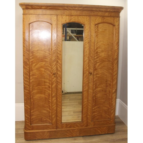 57 - A Victorian Satinwood triple wardrobe press, the mirror and panel doors enclosing 5 trays, 3 drawers... 