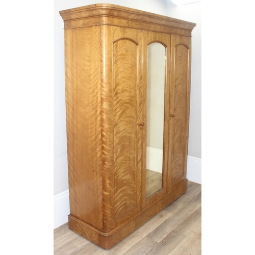 57 - A Victorian Satinwood triple wardrobe press, the mirror and panel doors enclosing 5 trays, 3 drawers... 