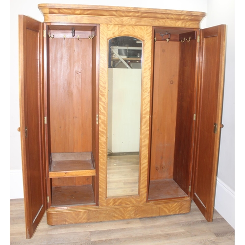 57 - A Victorian Satinwood triple wardrobe press, the mirror and panel doors enclosing 5 trays, 3 drawers... 