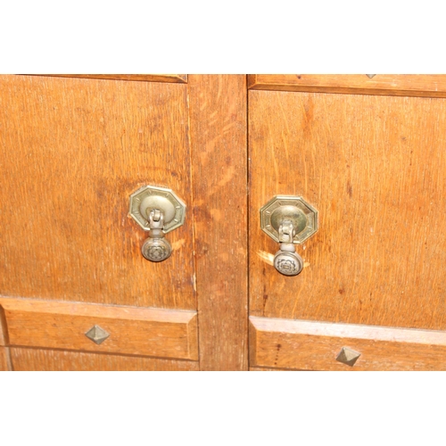 67 - A 17th century style oak sideboard with 2 drawers over 2 doors, brass drop handles, approx 122cm wid... 