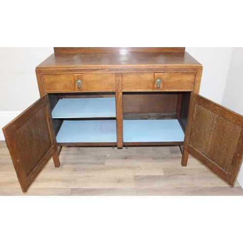 67 - A 17th century style oak sideboard with 2 drawers over 2 doors, brass drop handles, approx 122cm wid... 