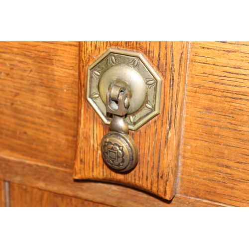 67 - A 17th century style oak sideboard with 2 drawers over 2 doors, brass drop handles, approx 122cm wid... 