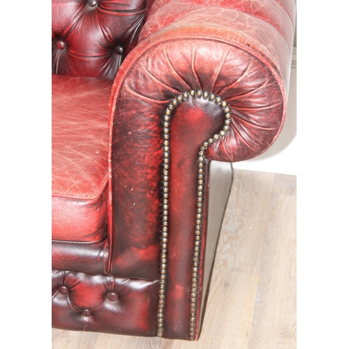 72 - A Chesterfield style distressed leather club chair, ox-blood red colouring, approx 108cm wide