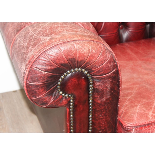 72 - A Chesterfield style distressed leather club chair, ox-blood red colouring, approx 108cm wide